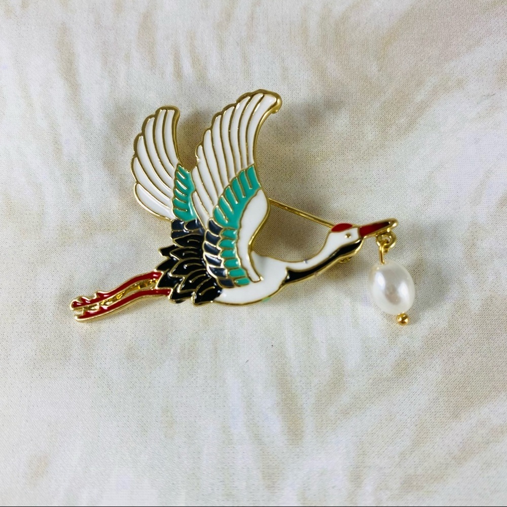 Beautiful little Japanese crane pin with a dangling Pearl in his beak.